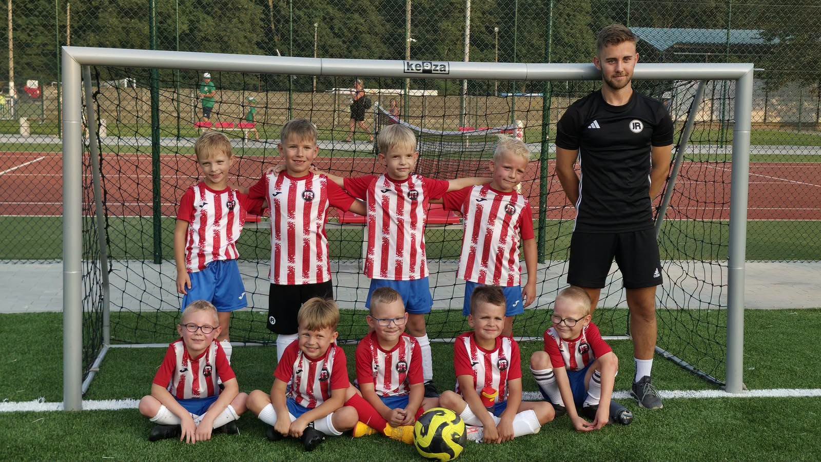 Młodsza grupa Junior Trening z trenerem przy bramce