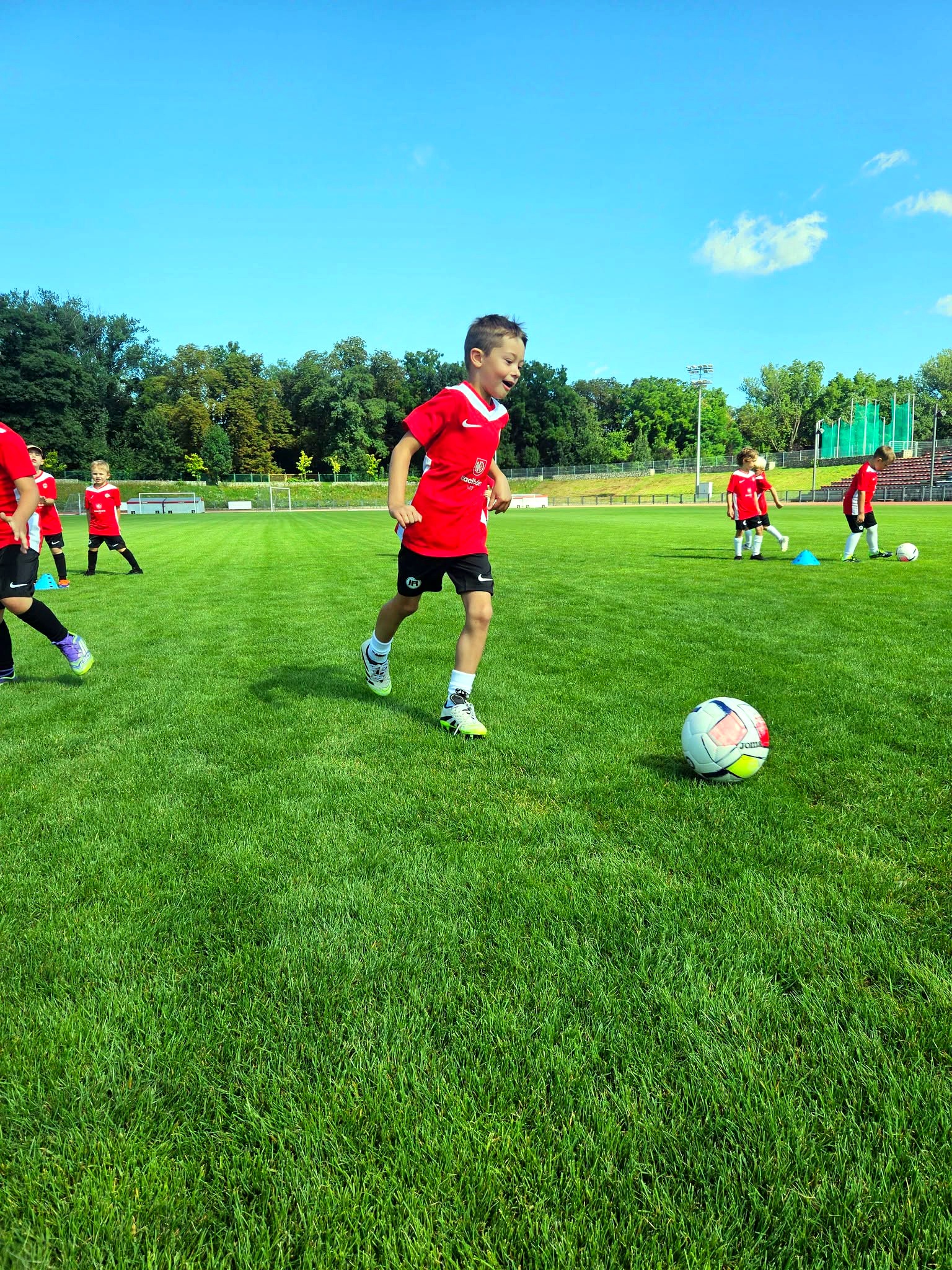 Dziecko biegnące za piłką na treningu Junior Trening